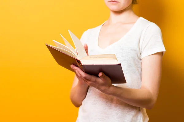 Una ragazza bruna brillante che legge un libro — Foto Stock