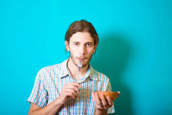 Estudiante comiendo de tenedor de cerámica — Foto de Stock