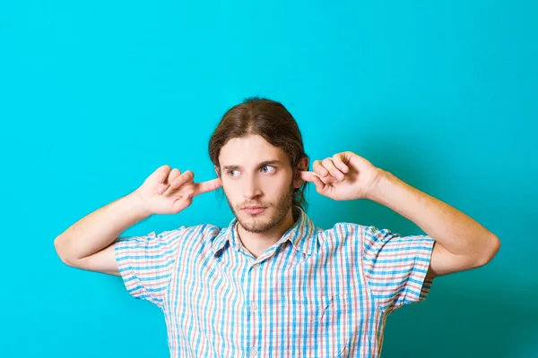 Young man covers his ears Stock Picture