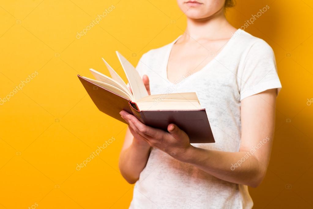 a bright brunette girl  reading a book