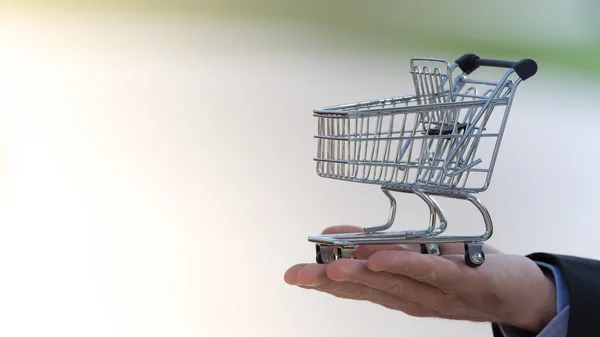 Businessman holding a shopping cart — Stock Photo, Image