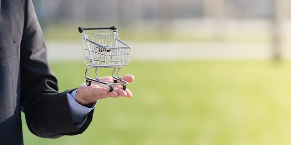 Businessman holding a shopping cart — Stock Photo, Image