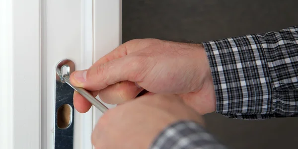 Reparador arreglando una cerradura de puerta — Foto de Stock