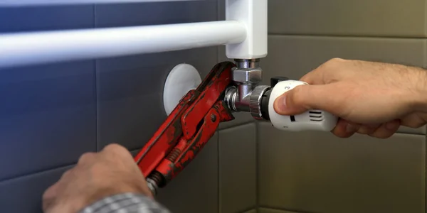 Plumber fixing a radiator — Stock Photo, Image