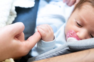 Huzurlu ve uykulu yeni doğan bebek, eline odaklan; aile ve aşk temalı fotoğrafçılık