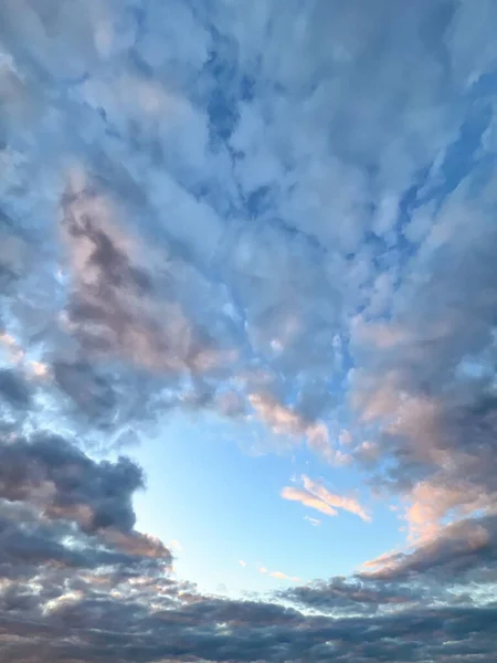 Mavi gökyüzü ve ışık bulutları bulutlu bir gökyüzünde açık bir aralıktan görülebilir.