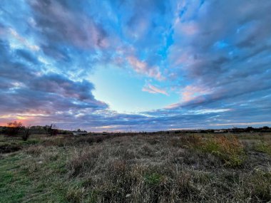 Gün batımında üzerinde gri ve mavi bulutlar olan açık alan