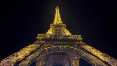 Eyfel Kulesi 'nin göz kamaştırıcı manzarası Paris' teki karanlık gece gökyüzüne karşı aydınlık ve ışıltılı