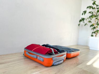 Giysilerle dolu bavul yerde yatıyor. Tatile çıkmaya hazır.