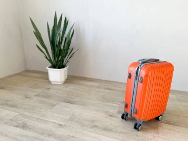 Ahşap zeminde duran turuncu bavullar kalkış ya da tatil için hazır.