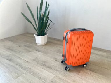 Turuncu bavul yolculuk ya da hafif ahşap zeminde yılan otuyla yolculuk için hazır.