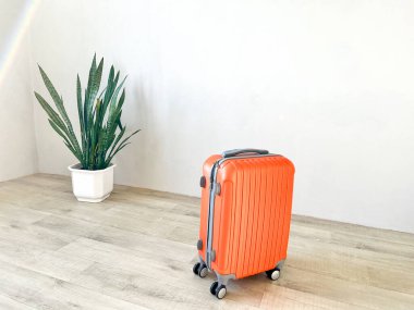 Ahşap zeminde parlak turuncu bavullar, tatile ya da iş gezisine hazır.