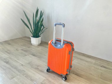Tekerlekli bavulun uzatılması gereken parlak turuncu bavul yolculuk için hazır.