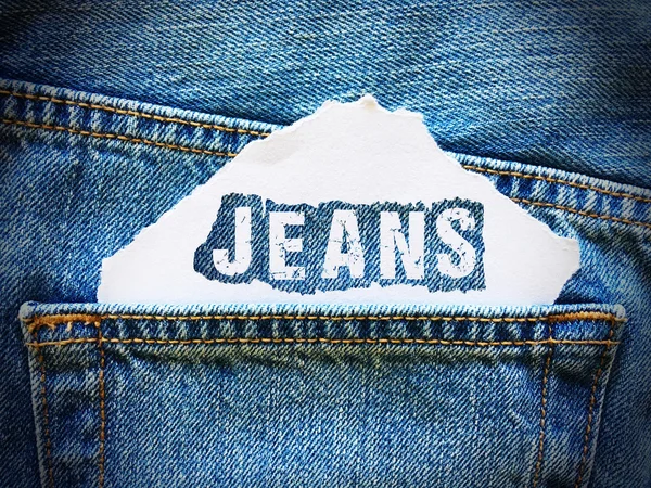 蓝色斜纹棉布牛仔裤口袋里的白纸上的牛仔裤字 — 图库照片