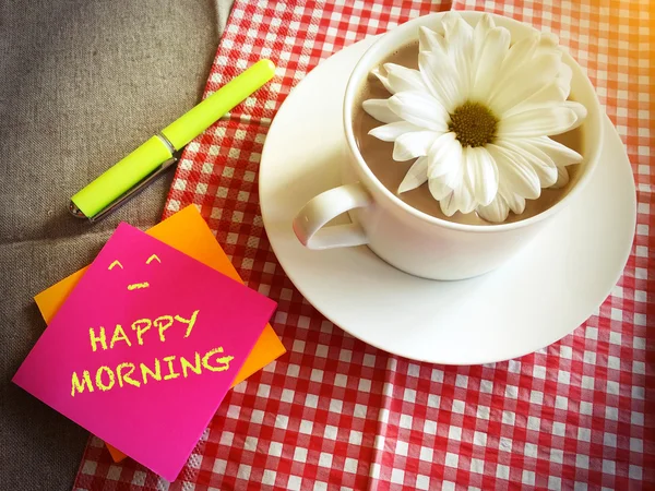 Xícara de café na mesa com margarida branca e palavras de manhã feliz vin — Fotografia de Stock