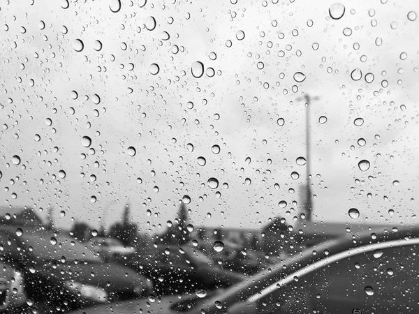 Gouttes de pluie sur la vitre de voiture en noir et blanc — Photo