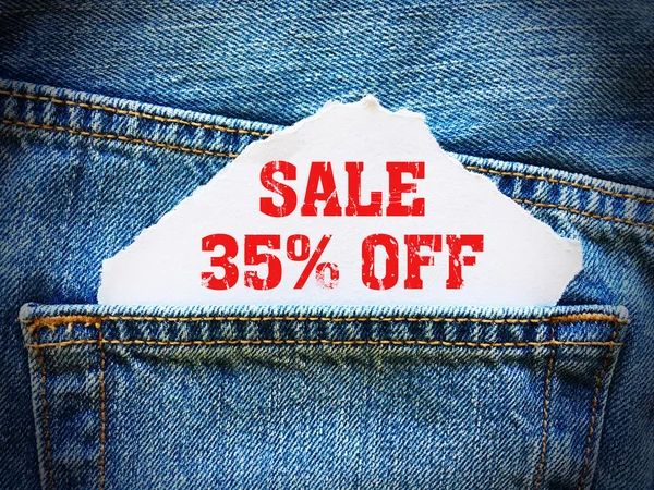青いデニムのジーンズのポケットに白い紙の上の 35% オフ — ストック写真