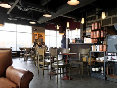 Ahşap sandalyeli rahat bir restoranın modern iç mekanı.