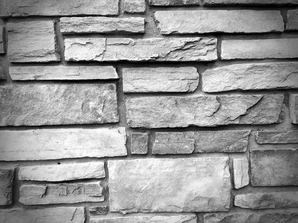 Uneven cracked stone wall texture background in balck and white — Stock Photo, Image