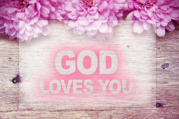 Růžové květy na dřevěné s slovo, Bůh vás miluje — Stock fotografie