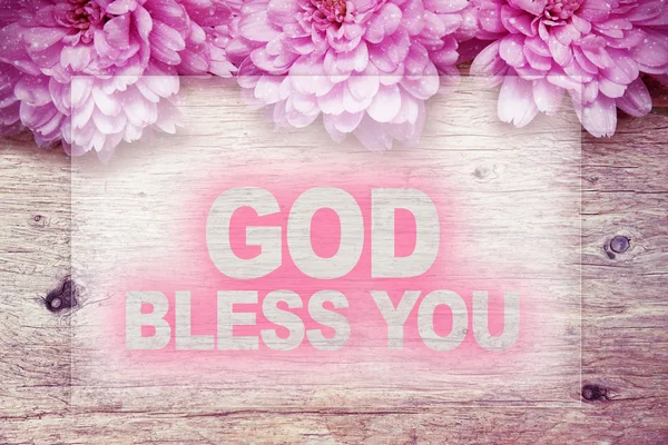 Pink flowers on wooden with word GOD BLESS YOU — Stock Photo, Image