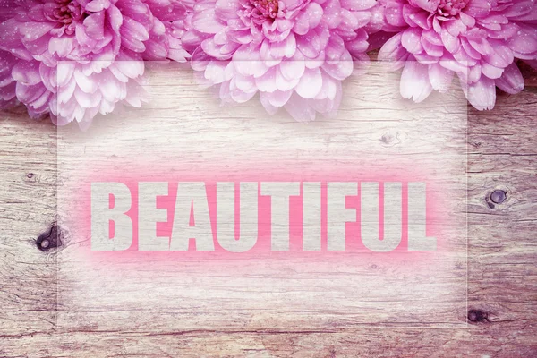 Ροζ λουλούδια σε ξύλινο με λέξη όμορφη — Φωτογραφία Αρχείου