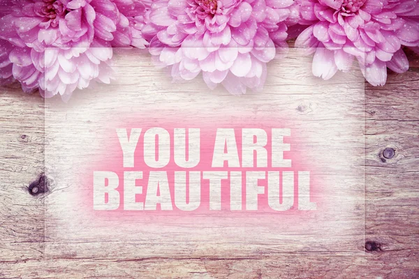 Flores de color rosa en madera con la palabra que eres hermosa —  Fotos de Stock