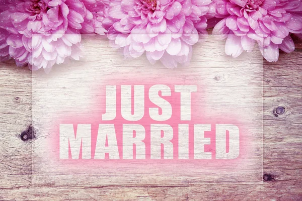 Pink flowers on wooden with word Just Married — Stock Photo, Image