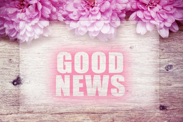 Pink flowers on wooden with word Good News — Stock Photo, Image