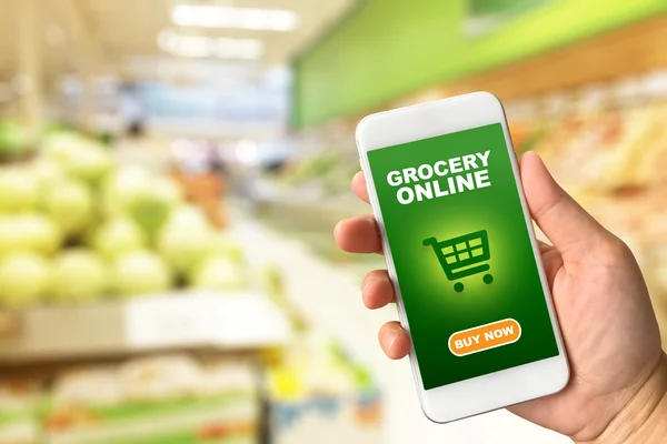 Kadın el smartphone mağaza backgr bulanıklık bokeh karşı tutarak