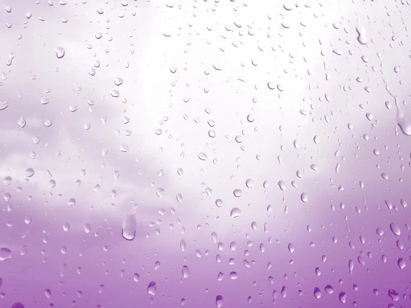 Gocce di pioggia su finestra di vetro, sfondo cielo viola — Foto Stock
