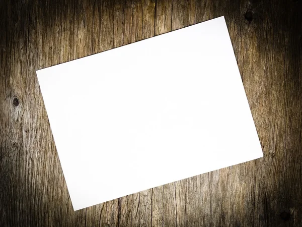 Prázdný dokument white paper o rozmazané dřevěné pozadí a černé vign — Stock fotografie