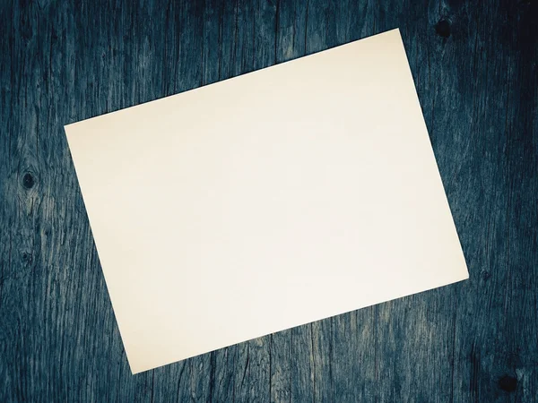 Простая старая белая бумага на размытом синем деревянном фоне — стоковое фото
