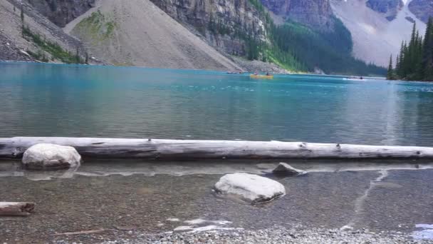 Hermoso lago, agua clara con desenfoque de la gente piragüismo en el fondo — Vídeo de stock