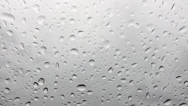 Detailní záběr z kapky vody, které jsou spuštěny na čelní sklo auta — Stock video