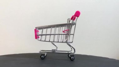 Mini metalik alışveriş arabası dönüyor.