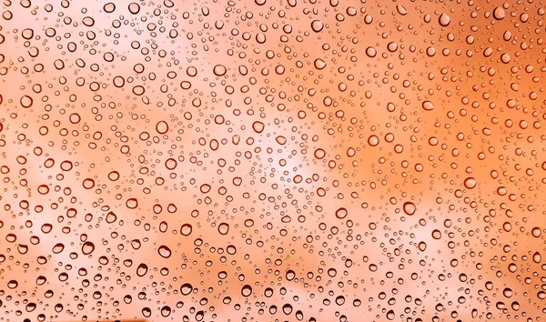 Gouttes de pluie sur fond dégradé verre orange — Photo