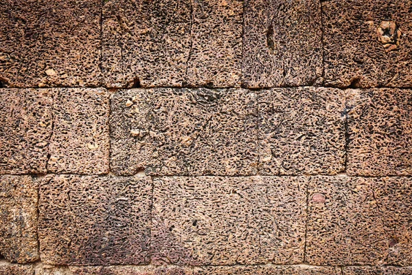 Textura irregular erosionada de una vieja pared de piedra — Foto de Stock