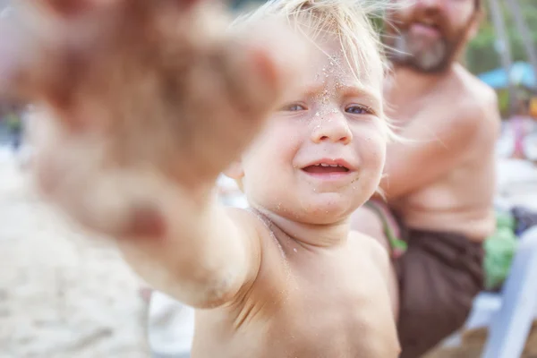 Bébé avec visage dans le sable — Photo