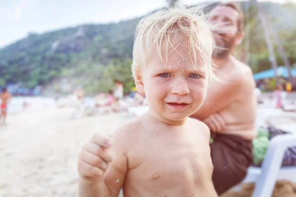 Bébé avec visage dans le sable — Photo