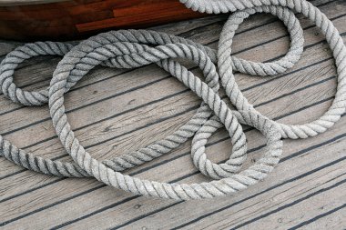 Coiled rope on a wooden deck clipart
