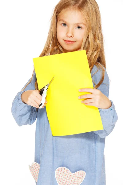 Menina bonito com tesoura e papel amarelo — Fotografia de Stock