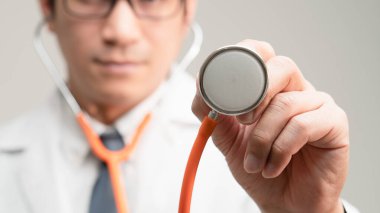 Doktorun eli steteskobu kameraya doğru kaldırsın. Hastalık belirtilerini fotokopi uzayı ile kontrol ediyormuş gibi yapsın. Geleneksel sağlık kontrolü, Corona virüsü krizinin sigorta geçmişi.