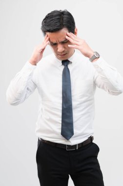 Yorgun Asyalı işçi başını sıkıp sıkı çalışmaktan kurtulmaya çalışıyor. Acı ifadesi, bitkin düşmüş konsept, ofis çalışanı yaşam tarzı, ofis sendromu, yorucu çalışma saati..