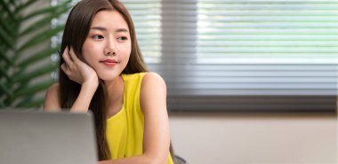 Genç, sevimli Asyalı ofis kadını hayal kuruyor ve sağa, fotokopi odasına bakıyor, rahat ve mutlu hissediyor, konsept mutlu ofis atmosferi, hayal kuruyor..