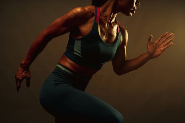 Sağdan gelen sıcak ışıkla bitiş çizgisine koşan, sağlıklı yaşam tarzı ve spor anlayışı için koşan Asyalı atletik kadının zayıf kaslarını kapatın..