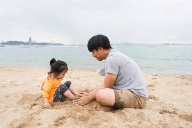 Baba ve kızı hafta sonu birlikte ve plajda vakit geçiriyorlar..