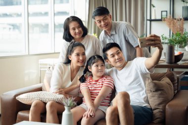 Gülümseyen ve kahkahalı cep telefonu, aile portresi, kaliteli zaman, büyükanne ve torun kullanarak selfie çekmenin keyfini çıkarın.