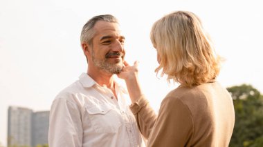 Son sınıf beyaz çiftin birbirlerine sarılıp mutlu oldukları öğleden sonra güneşi, yaşlı çiftin yıldönümleri, birliktelikleri, mutlu emeklilikleri, romantik çiftler, aşk ifadeleri.