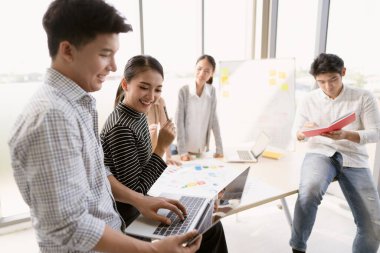 Asyalı bir girişimci grubunun yoğun bir iş toplantısı, takım çalışması kavramı, beyin fırtınası pazarlama planı ve yeni fikirler, iş yerinde kendine güvenen bir iş kadını, yeni bir iş kurma.
